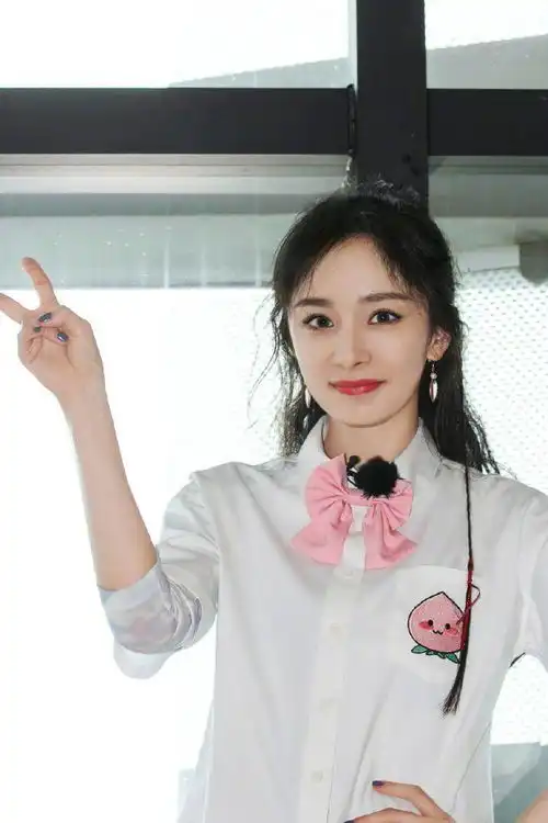 杨幂梳双马尾戴粉色领结对镜比剪刀手少女感满满
