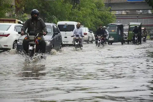 巴基斯坦遭遇暴雨民众洪水中前行
